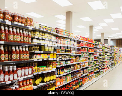 Stocked shelves in grocery store aisle Stock Photo