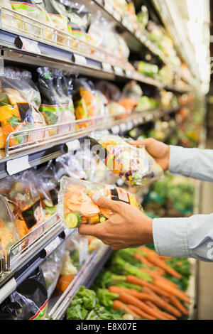 Close up of man comparing produce in grocery store Stock Photo