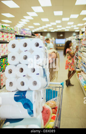 Woman pushing full shopping cart in grocery store Stock Photo