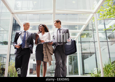Business people walking out of office building together Stock Photo
