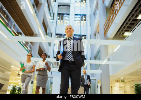 Business people walking through office building Stock Photo