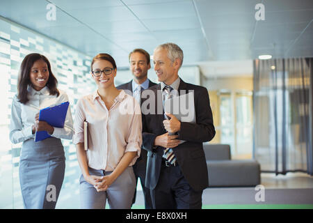 Business people walking through office building together Stock Photo