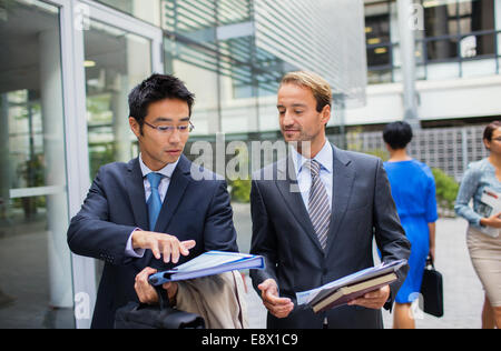 Businessmen talking outside of office building Stock Photo