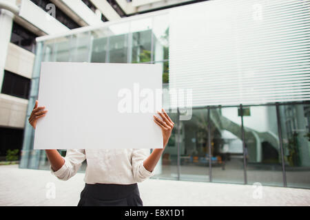 Businesswoman holding cardboard outside of office building Stock Photo