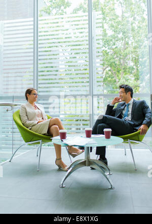Business people talking at coffee table in office building Stock Photo