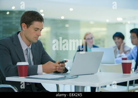 Businessman using cell phone in office building cafe Stock Photo