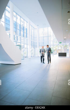 Businessmen walking together in office building Stock Photo