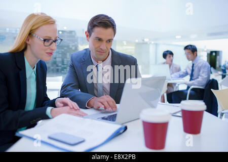 Business people working on laptops at table Stock Photo
