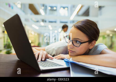 Businesswoman relaxing with laptop in office building Stock Photo