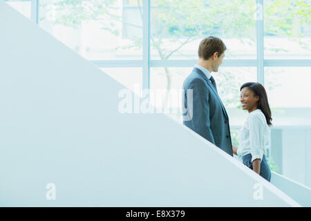 Business people crossing paths on staircase Stock Photo