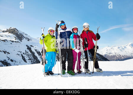 Family carrying skis on mountain top Stock Photo