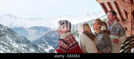 Family looking out from balcony together Stock Photo