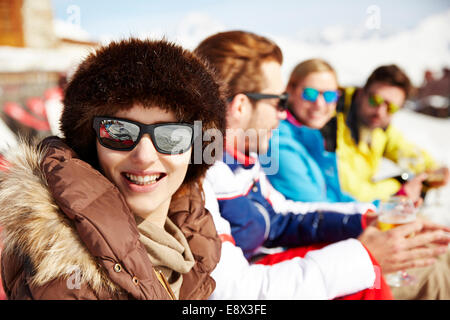 Woman sitting with friends in the snow Stock Photo