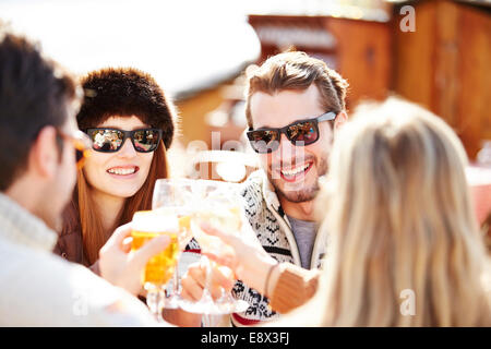 Friends celebrating with drinks in the snow Stock Photo