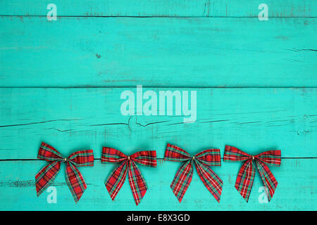 Blank antique green distressed wooden background with red plaid Christmas bows border Stock Photo