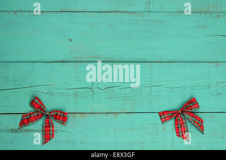 Blank antique green weathered wood background with red plaid Christmas bows border Stock Photo