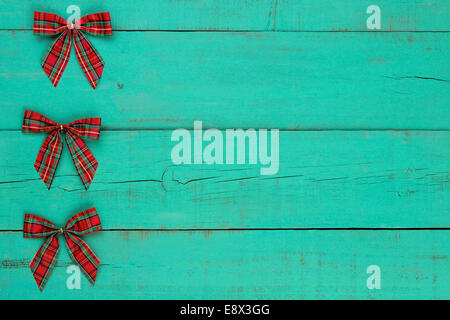 Blank antique green rustic wooden background with red plaid Christmas bows border Stock Photo