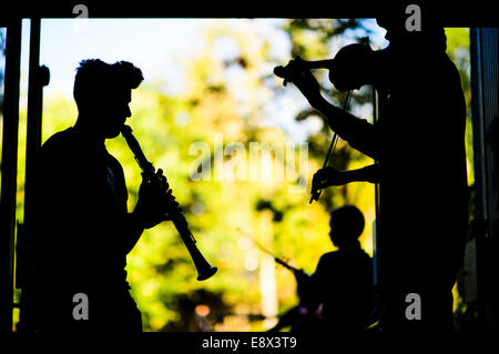 Young teenage musicians rehearsing playing clarinet and violin in silhouette at Aberystwyth MusicFest 2014 Stock Photo