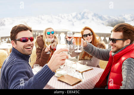 Friends celebrating with drinks in the snow Stock Photo