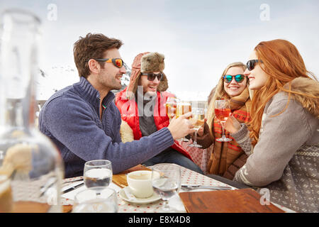 Friends celebrating with drinks in the snow Stock Photo