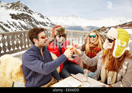 Friends celebrating with drinks in the snow Stock Photo