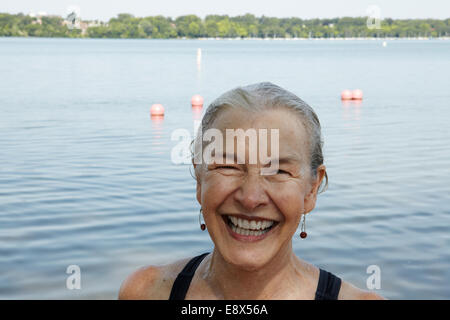 66 year old senior woman swimming in lake Stock Photo