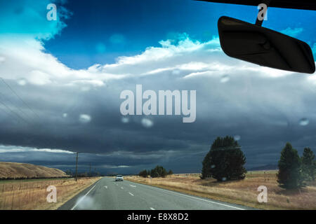 New Zealand weather can be unpredictable. Driving into a rainstorm on Highway 8 near Omarama. First rain drops on the windshield Stock Photo