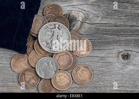Close up view of a bag of United States vintage coins spilling out onto rustic wood Stock Photo