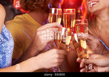 Five hands raising champagne flutes in a toast Stock Photo