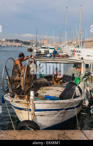 Two fishermen tending to their nets at the Marseille daily fish market in the Vieux Port Stock Photo