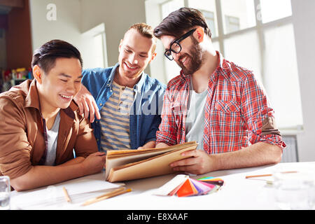 Team of three designers discussing a project Stock Photo