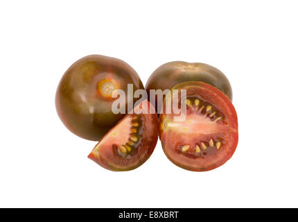 Black Tomatoes whole and cut on a white isolated background Stock Photo
