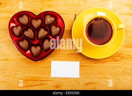chocolate pralines in red heart shape box on table Stock Photo