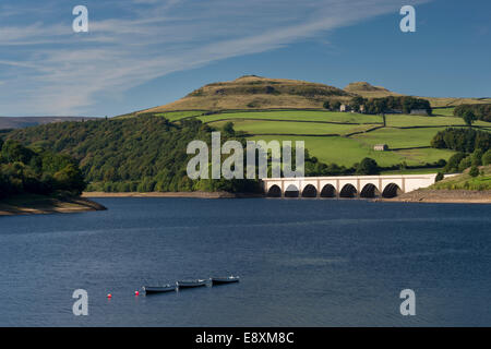 Blue summer sky over water of Ladybower Reservoir, boats moored, arches of Ashopton Viaduct & scenic hillside - Derbyshire peak District, England, UK. Stock Photo