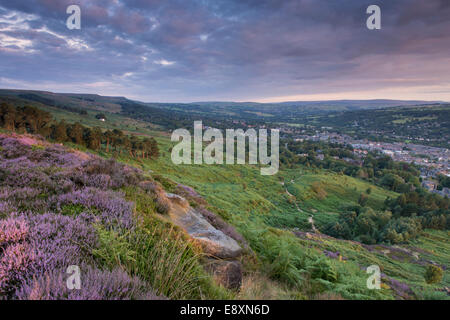 Under dramatic clouds, scenic rural morning sunrise view from high on Ilkley Moor, over town nestling in Wharfe Valley - West Yorkshire, England, UK. Stock Photo