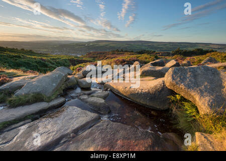 Under dramatic blue sky, scenic rural sunny evening view from high on Ilkley Moor, over town nestling in Wharfe Valley - West Yorkshire, England, UK. Stock Photo