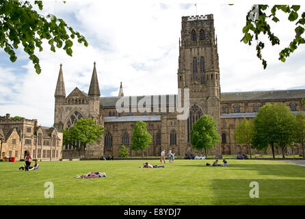 People relaxing on green in front of Durham Cathedral UK Stock Photo