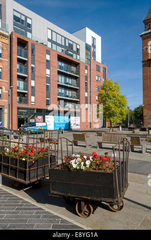 Trolleys, formerly used in the cotton mills, and the Ice Plant building at Cutting Room Square, Ancoats, Manchester, England, UK Stock Photo