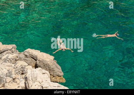 Tourists swimming in Lucisca bay near Sveta Nedilja village, Hvar island, Croatia Stock Photo