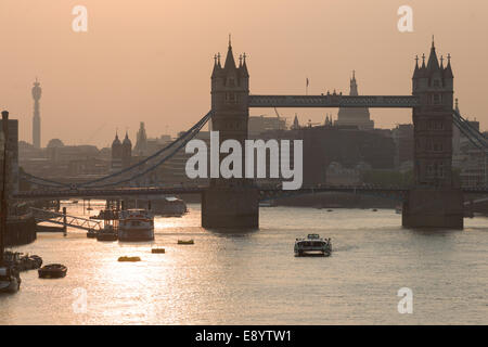 Tourist boat on the River Thames, passing Tower Bridge at sunset, London, England Stock Photo