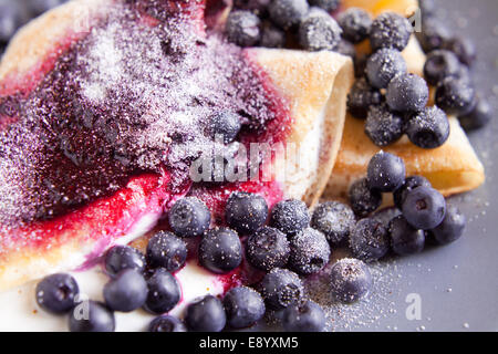 Blueberry and soft cheese pancakes on blue plate. Perfect meal for fresh breakfast. Stock Photo