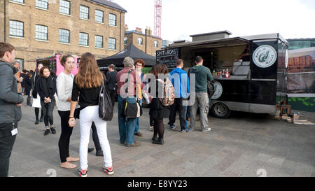 London UK. 16th October 2014. On a warm autumn afternoon people queue to buy lunch from KERB street food vans on the forecourt outside UAL University of the Arts in Kings Cross.  KATHY DEWITT/Alamy Live News Stock Photo