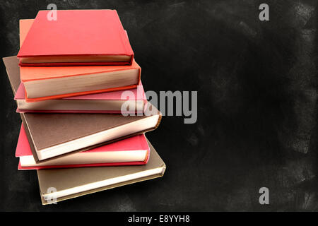 Pile of books in front of blackboard Stock Photo