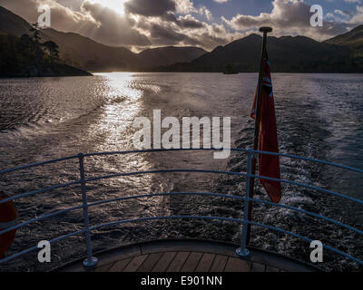 Sunlight on waters of Ullswater Lake and with distant mountains seen from the stern of 'The Raven' Steamer, Cumbria, England, UK Stock Photo