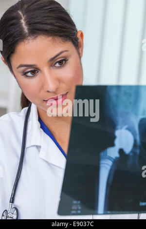 A Latina Hispanic female medical doctor surgeon looking at hip replacement x-ray in a hospital Stock Photo