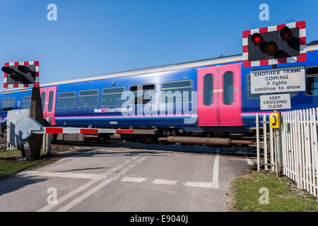 A First Great Western passenger train passes the level crossing at Ufton Nervet, Berkshire, England, UK. Stock Photo