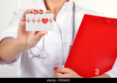 female doctor holding business card with heartbeat Stock Photo