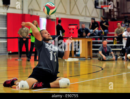 Retired U.S. Army Spc. Kyle Butcher serves during a sitting volleyball game between the U.S. Special Operations Command team and the Navy team during the 2014 Warrior Games in Colorado Springs, Colo., Sept. 28, 2014. The Warrior Games is an annual event a Stock Photo