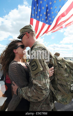 U.S. Army Spc. Tyler Deibert, with the 1742nd Transportation Company, South Dakota Army National Guard, embraces his wife, Shasta, during a homecoming ceremony at the Sanford Pentagon in Sioux Falls, S.D., Oct. 7, 2014. Soldiers with the unit returned fro Stock Photo