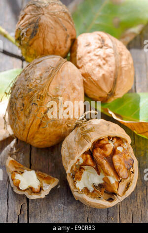 Walnut and leaves on  old wooden table Stock Photo